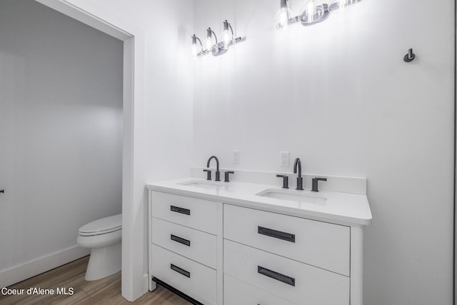 bathroom with vanity, wood-type flooring, and toilet