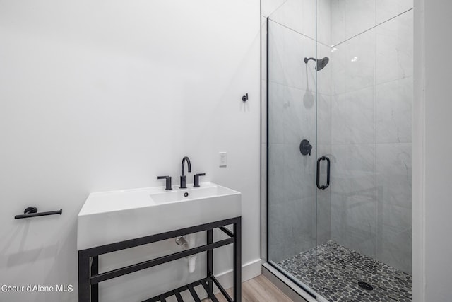 bathroom with hardwood / wood-style flooring, sink, and walk in shower