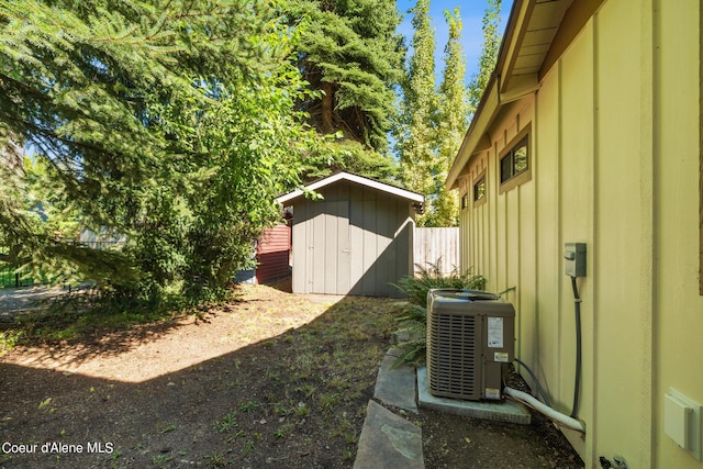 view of yard with central AC unit and a storage shed