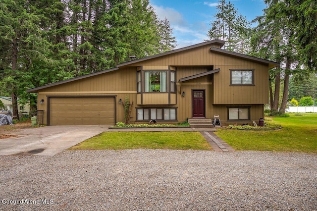 bi-level home featuring a garage and a front lawn