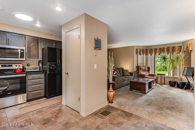 kitchen featuring light carpet and stainless steel appliances