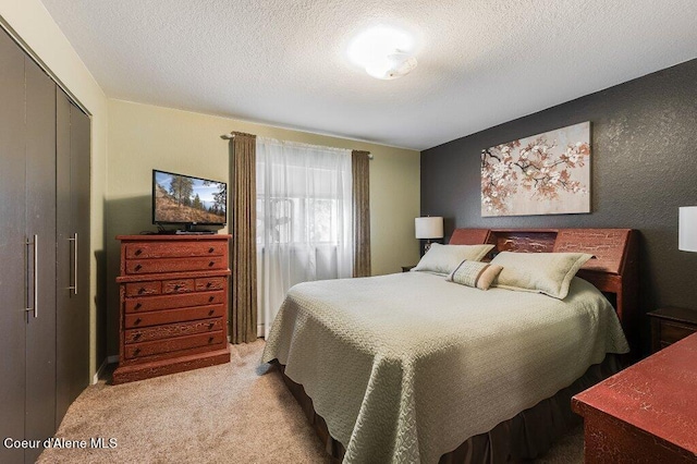 carpeted bedroom with a textured ceiling and a closet