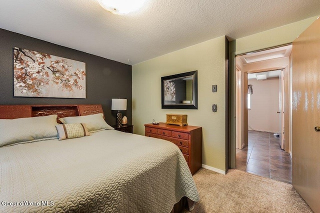 bedroom with a textured ceiling and light colored carpet