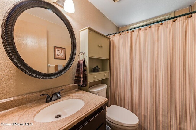 bathroom featuring vanity, toilet, and walk in shower