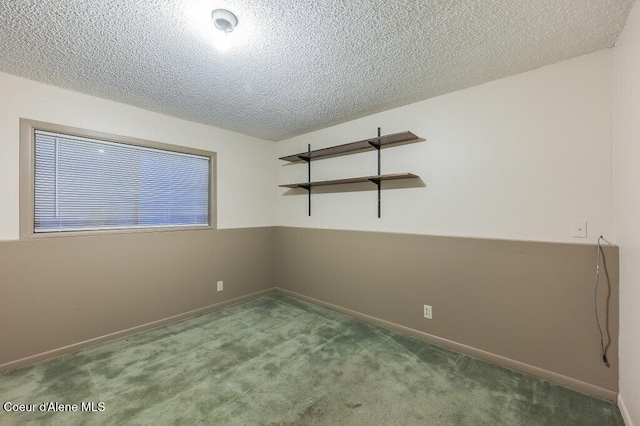 carpeted empty room featuring a textured ceiling