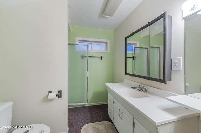 bathroom featuring a textured ceiling, a shower with door, toilet, and vanity