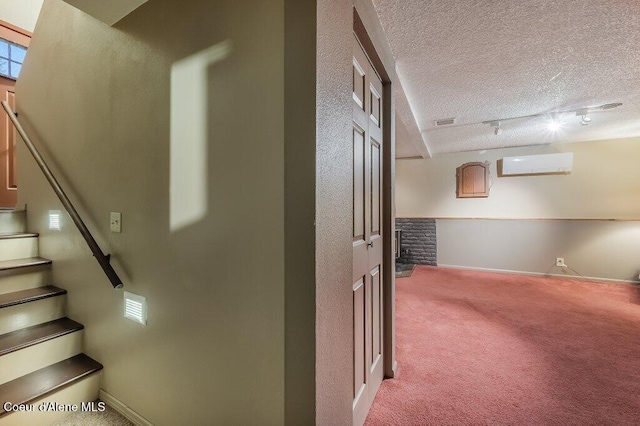 staircase with carpet flooring, a textured ceiling, and a wall unit AC