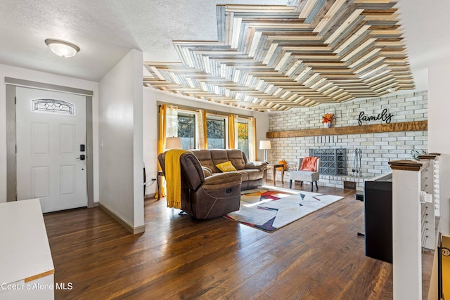 living room with dark wood-type flooring, a fireplace, and a textured ceiling