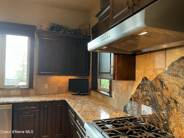 kitchen featuring dark brown cabinets, gas range, and tasteful backsplash