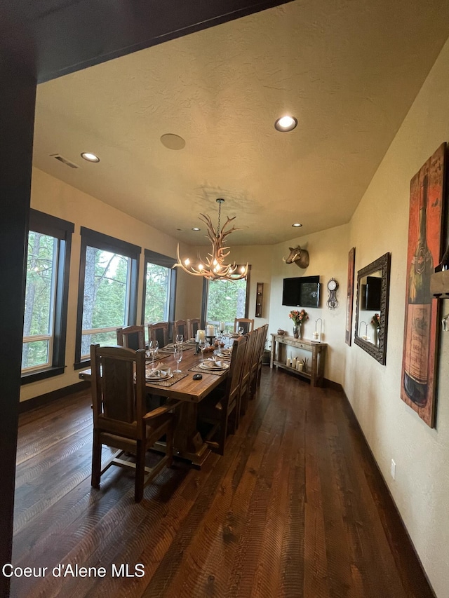 dining area with dark hardwood / wood-style floors and a chandelier