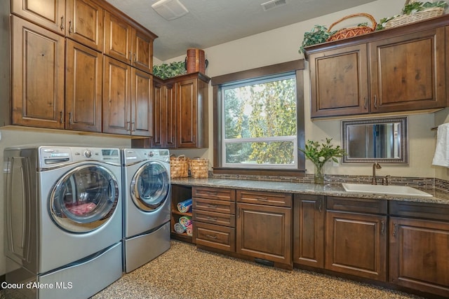 clothes washing area with cabinets, independent washer and dryer, and sink