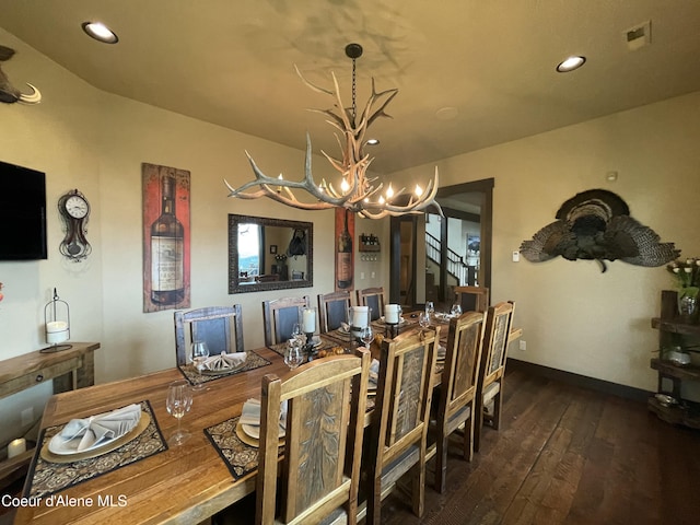 dining space featuring dark wood-type flooring and an inviting chandelier