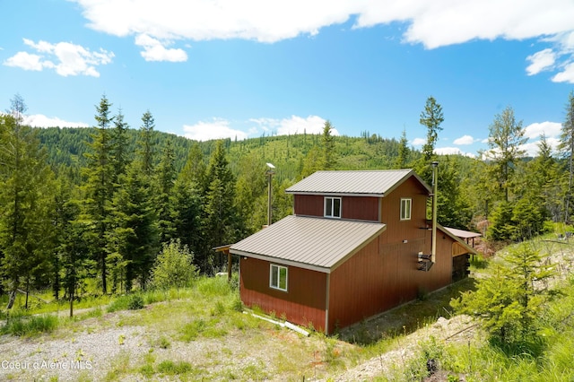 4333 Old Highway Two Loop, Moyie Springs, ID 83845 - view of side of home with a forest view, a metal roof, a barn, and an outbuilding