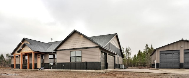 view of front of property with a garage, cooling unit, and a porch