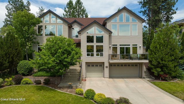 view of front of property featuring stairs, concrete driveway, and a garage