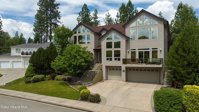 view of front facade featuring an attached garage, concrete driveway, and stairs