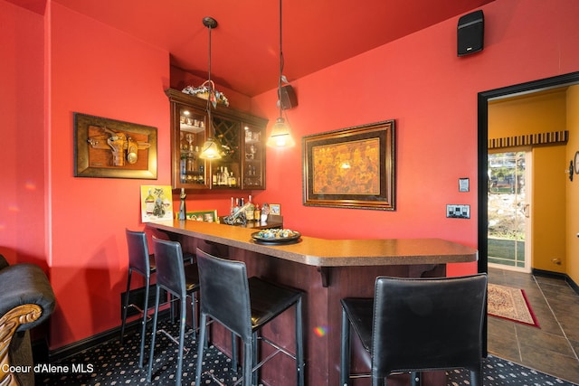 bar featuring hanging light fixtures, a dry bar, and baseboards