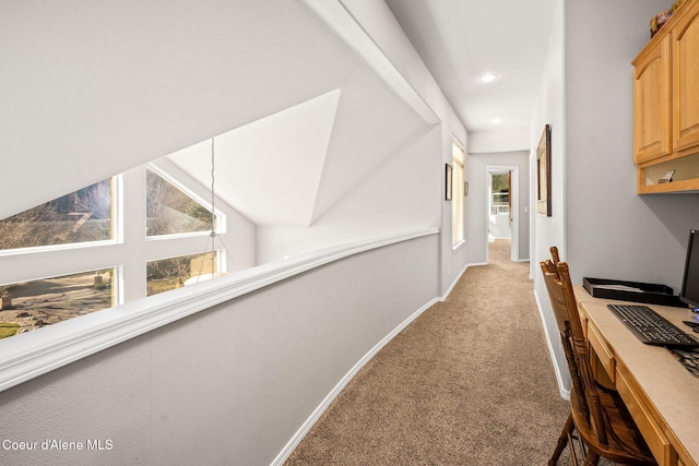 hallway with recessed lighting, light colored carpet, lofted ceiling, and baseboards