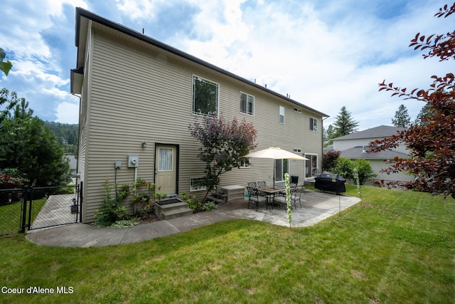 rear view of house with a gate, fence, a yard, entry steps, and a patio area