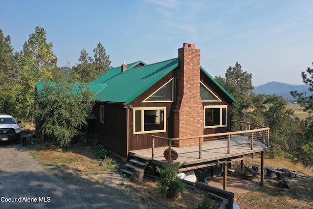 view of side of home with a deck with mountain view