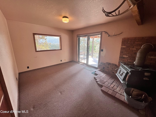 unfurnished living room featuring a textured ceiling and beam ceiling