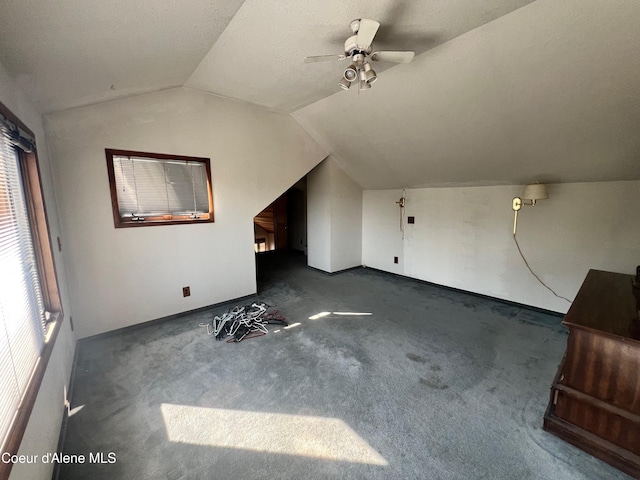 bonus room with ceiling fan, dark colored carpet, a textured ceiling, and lofted ceiling