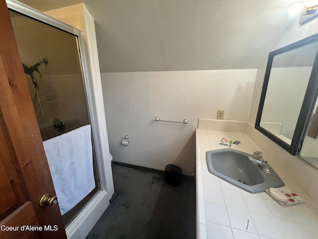 bathroom featuring sink, a shower with door, and lofted ceiling