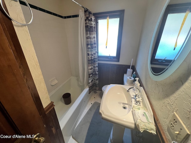 bathroom with toilet and shower / tub combo with curtain