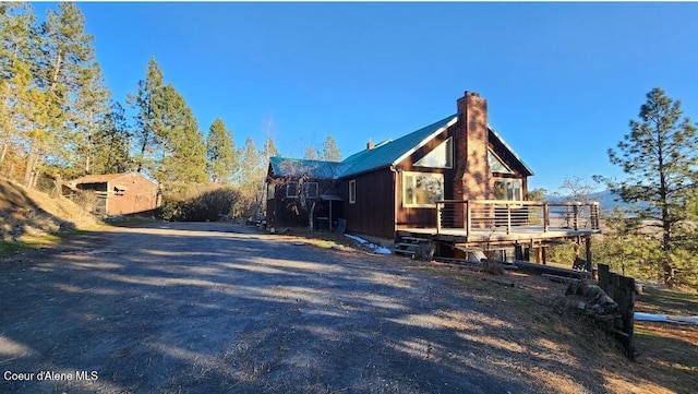 view of home's exterior with a wooden deck and a shed