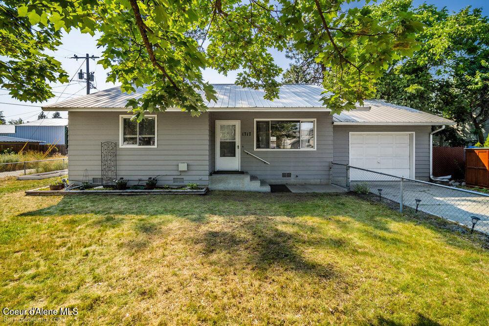 single story home with a garage and a front lawn