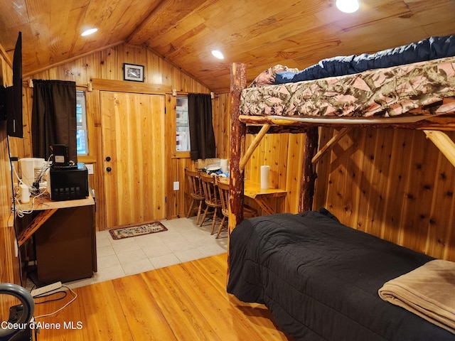 bedroom featuring wood walls, light tile patterned floors, wooden ceiling, and vaulted ceiling