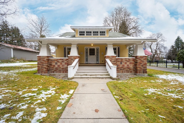 view of front of home with covered porch and a front lawn