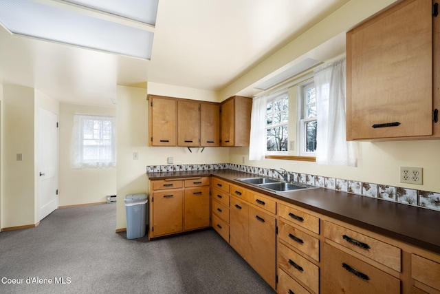 kitchen featuring a baseboard radiator, dark carpet, and sink