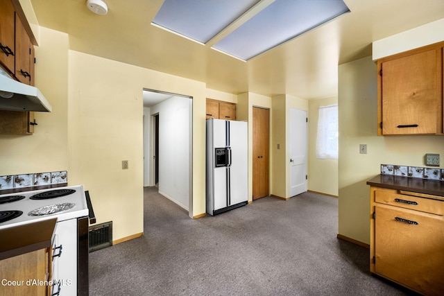 kitchen with electric stove, carpet floors, and white refrigerator with ice dispenser