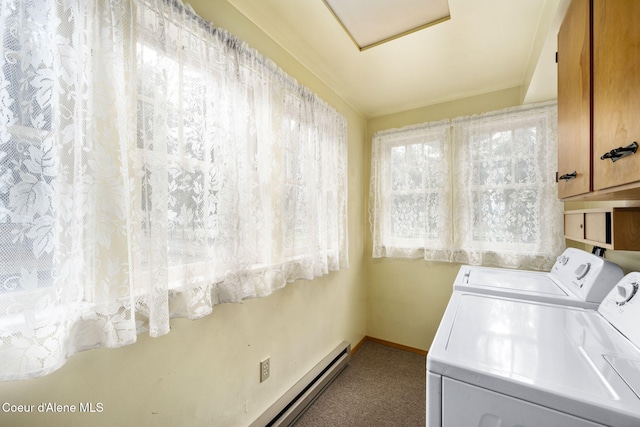 clothes washing area featuring washing machine and clothes dryer, a healthy amount of sunlight, and cabinets