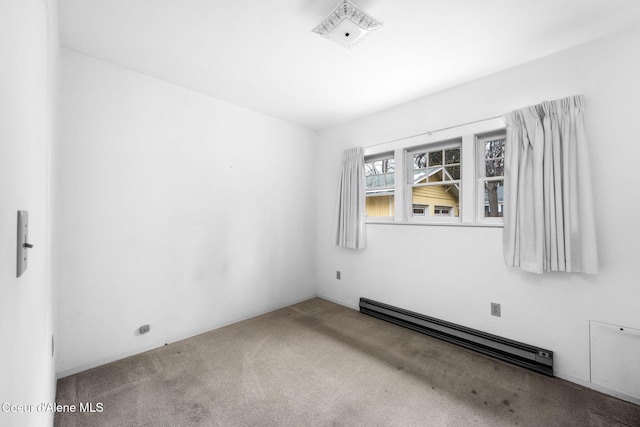 spare room with carpet floors and a baseboard heating unit