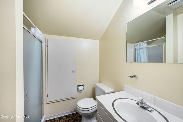 bathroom featuring toilet, vanity, lofted ceiling, and walk in shower