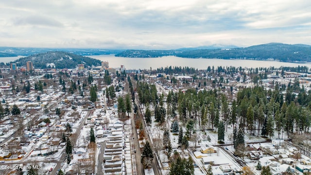 snowy aerial view with a water and mountain view