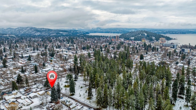 snowy aerial view with a water and mountain view