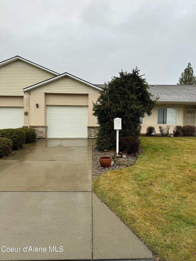 single story home with a garage and a front lawn