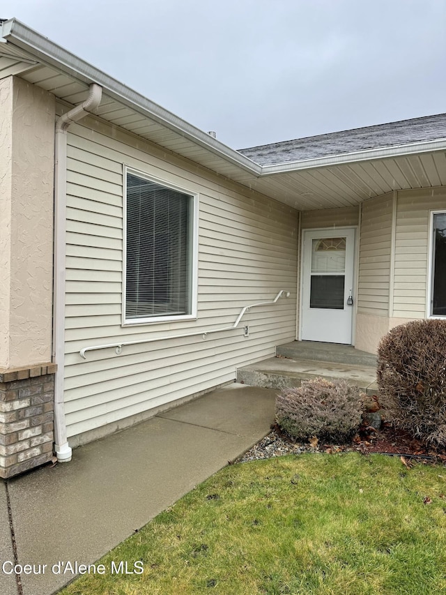 doorway to property with a yard