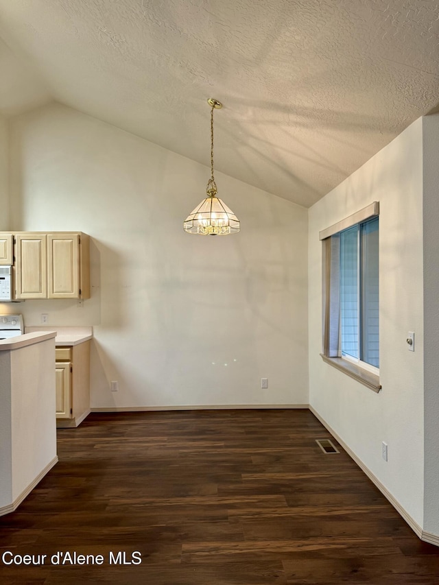 unfurnished dining area with dark wood-type flooring, lofted ceiling, and a notable chandelier