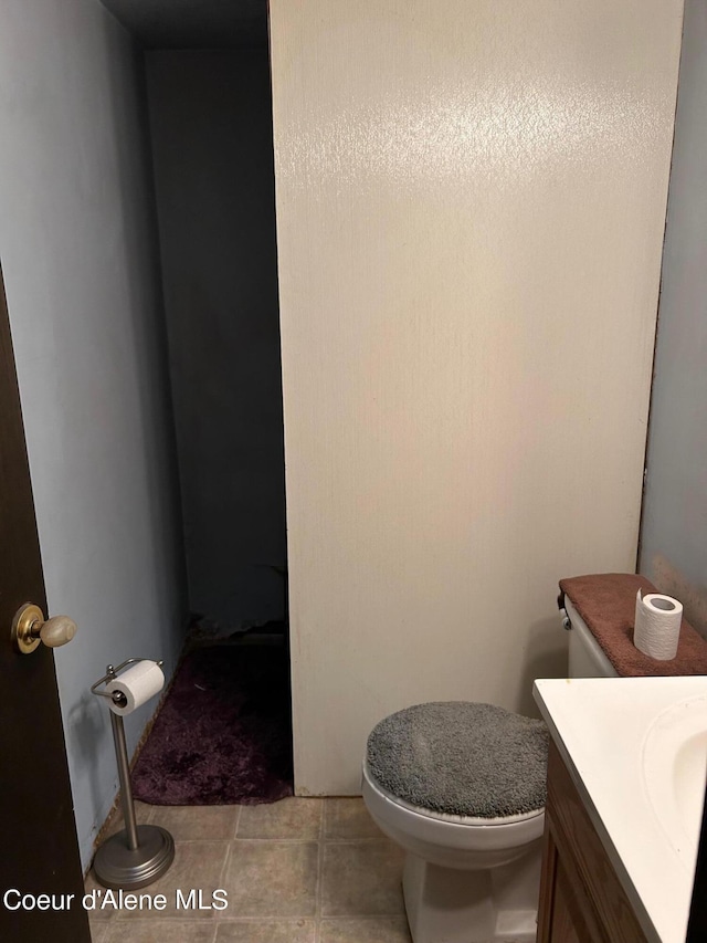 bathroom with tile patterned flooring, vanity, and toilet