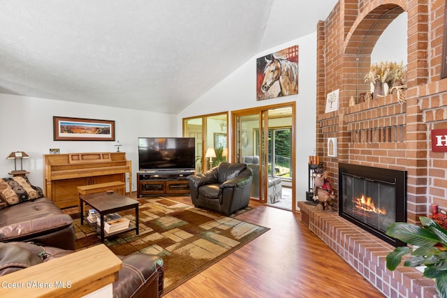 living room with hardwood / wood-style flooring, vaulted ceiling, and a brick fireplace