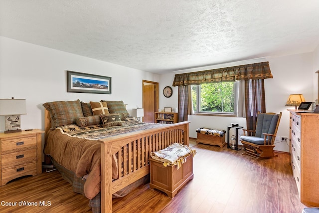 bedroom with wood-type flooring and a textured ceiling