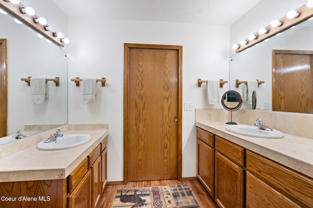 bathroom featuring hardwood / wood-style floors, vanity, and a textured ceiling