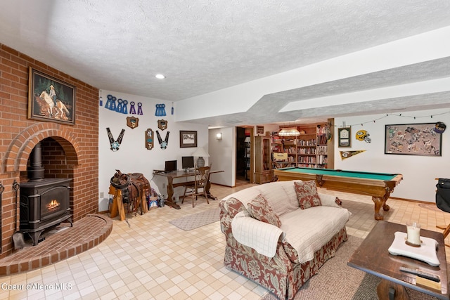 playroom featuring a wood stove, a textured ceiling, and pool table