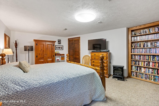 bedroom with carpet flooring, a wood stove, a textured ceiling, and a closet