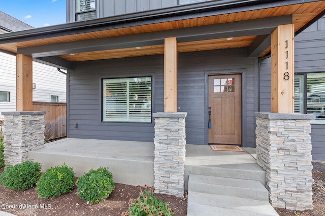 view of exterior entry featuring covered porch