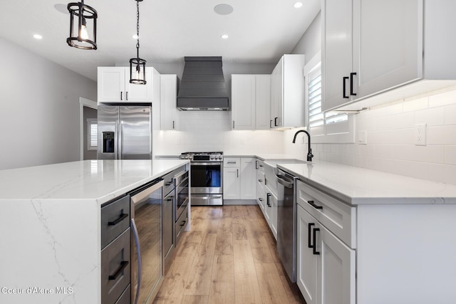 kitchen featuring premium range hood, pendant lighting, white cabinets, and stainless steel appliances